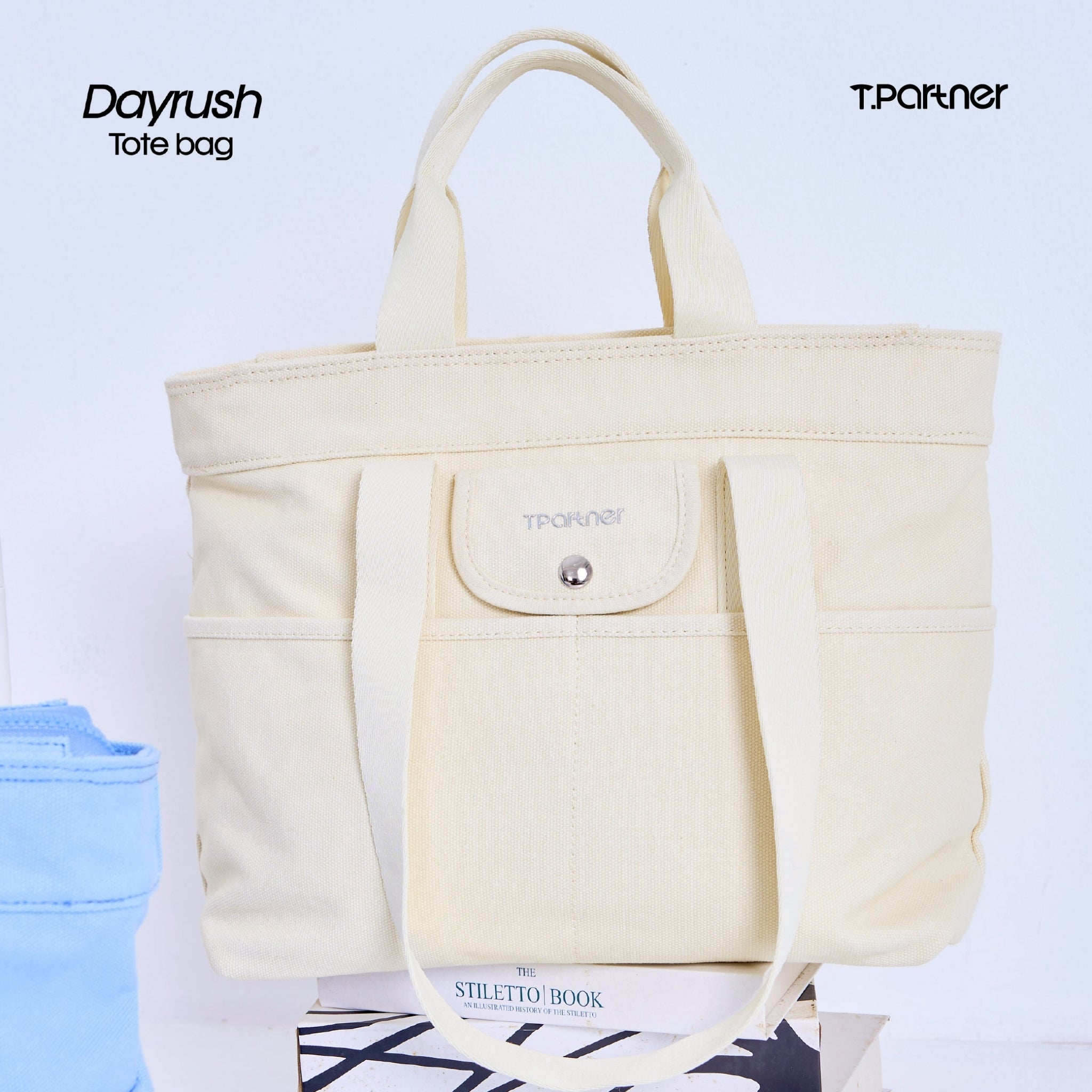 กระเป๋าโท้ท DayRush สีครีมอ่อน ทำจากผ้าแคนวาส มีช่องใส่ของด้านหน้าและสายสะพาย.