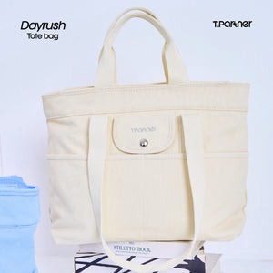 กระเป๋าโท้ท DayRush สีครีมอ่อน ทำจากผ้าแคนวาส มีช่องใส่ของด้านหน้าและสายสะพาย.