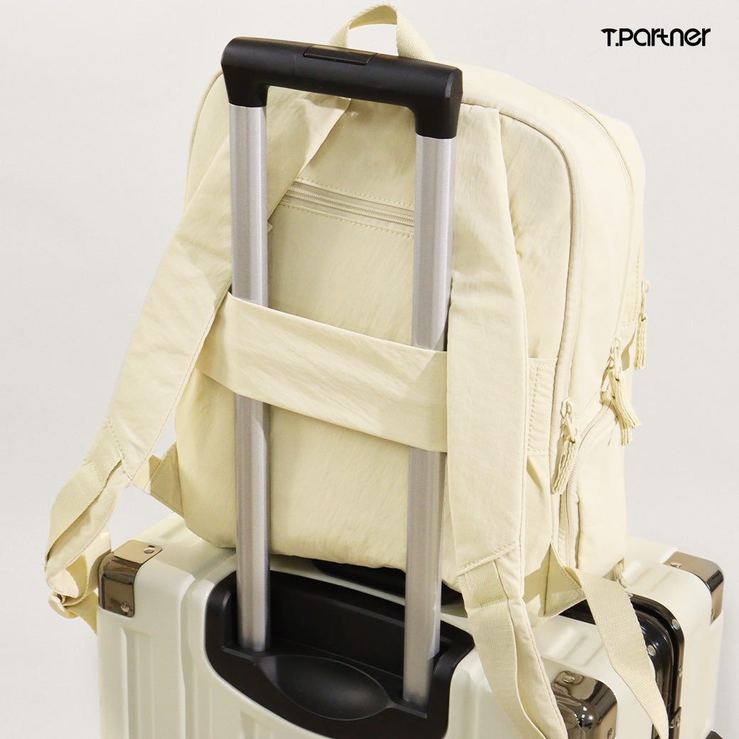 กระเป๋าเป้ Puffy Back Pack สีครีม วางบนกระเป๋าเดินทางใบใหญ่